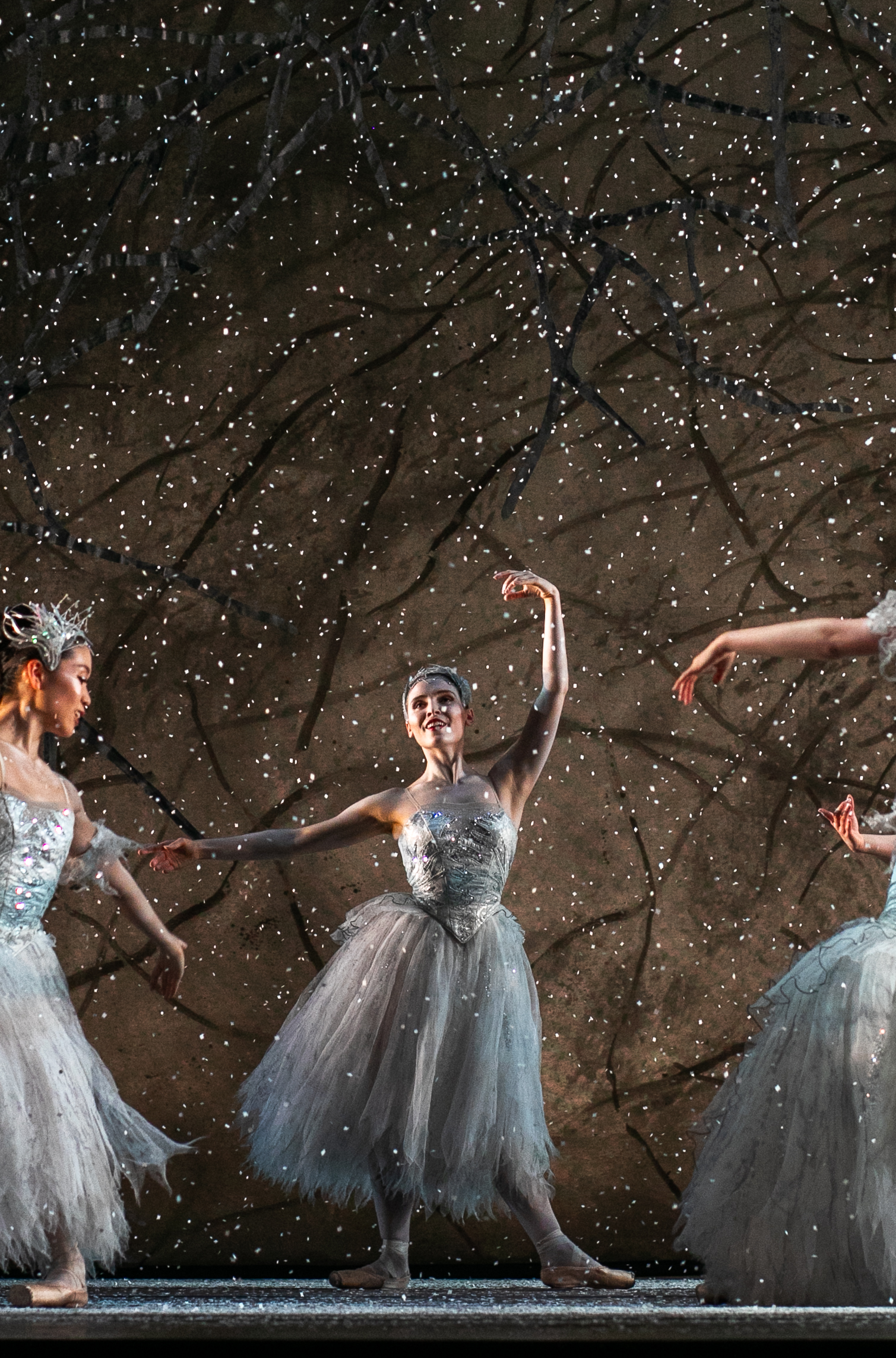 Hannah performing with an ensemble beneath falling stage snow