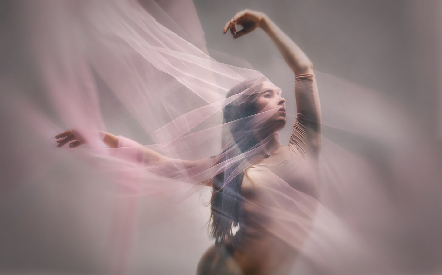 Hannah extending her arms through pink fabric