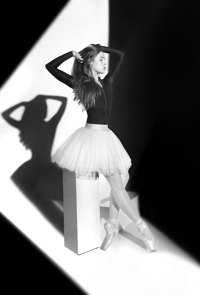 Hannah in a white tutu, framed by geometric light and shadow