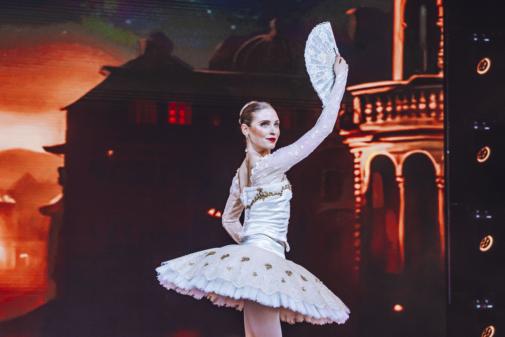 Hannah performing in a white tutu with a fan