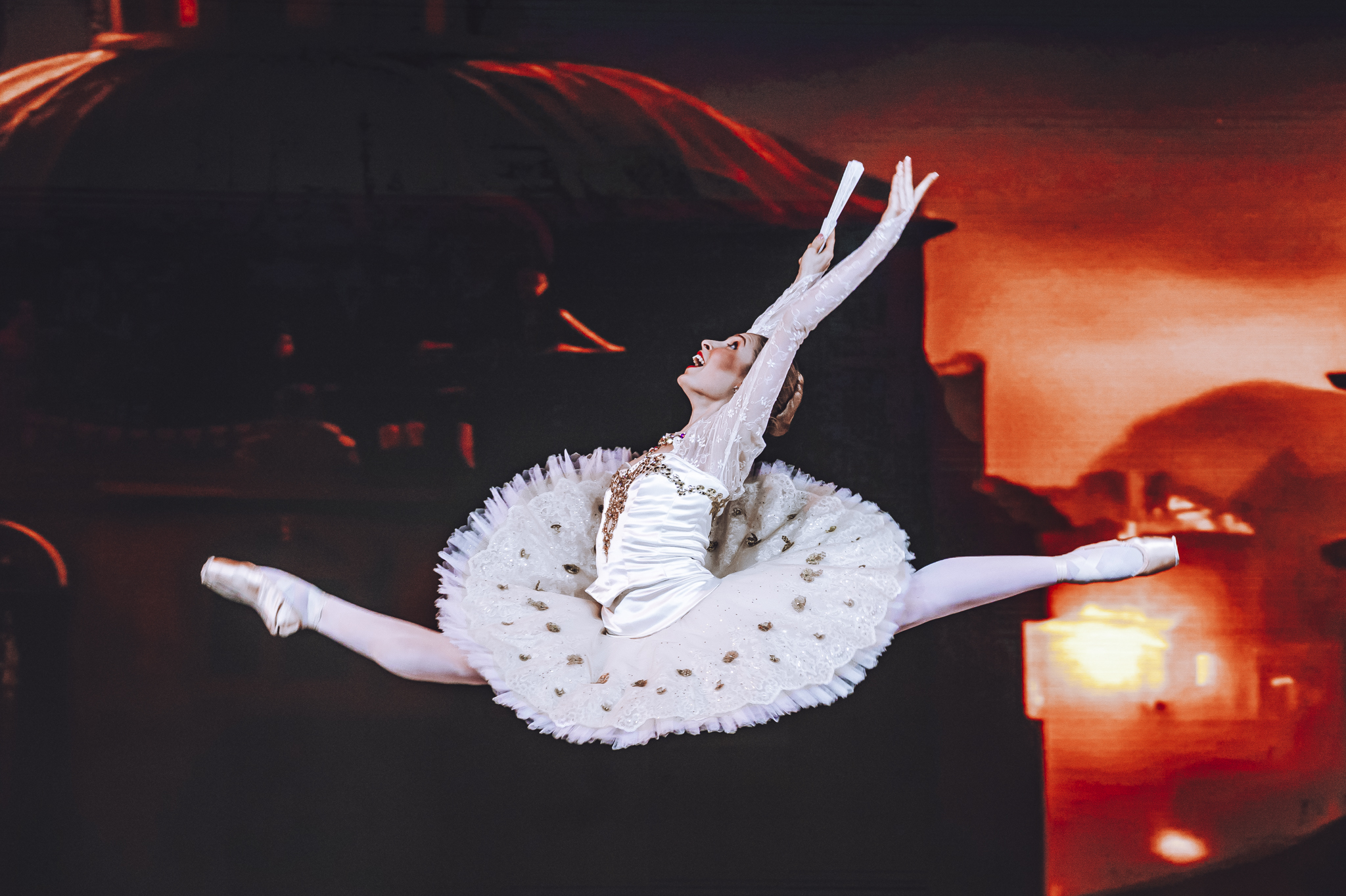 Hannah in a split leap on stage in a classical tutu